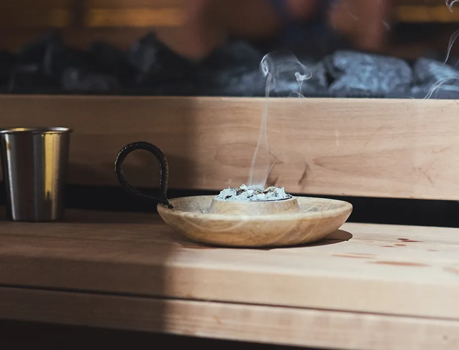 Traditional sauna wooden bowl and aromatherapy setup used during Aufguss ceremonies.