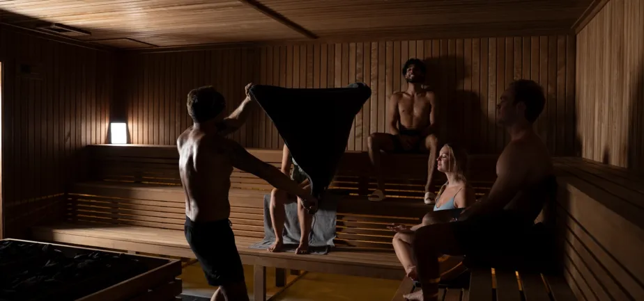 Community members and sauna crew gathering inside the wood-finished wellness studio at Pure Heat Club.
